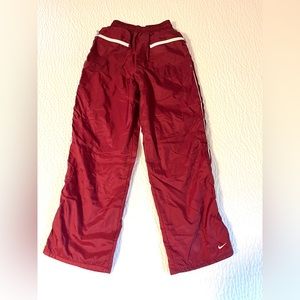 Women’s Nike athletic pants with front zippered pockets. Maroon color.